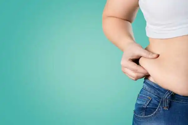 Image of woman pinching her love handles to show weight gain Kingswinford